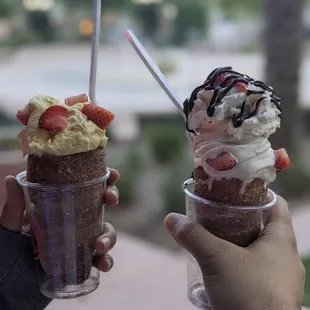 two people holding up their ice cream sundaes