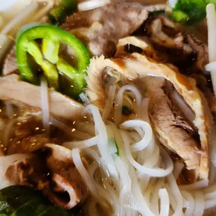 a bowl of noodles with meat and vegetables