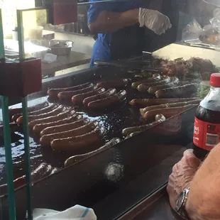 a man cooking hot dogs