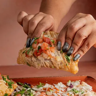 a person taking a slice of pizza