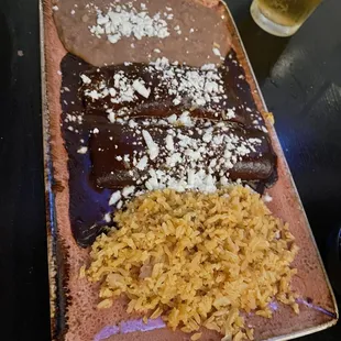 Mole enchiladas with rice and refried beans