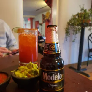 a beer and a bowl of guacamole