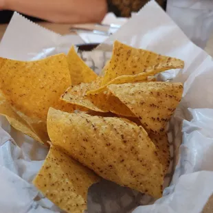 a basket of chips and a glass of water