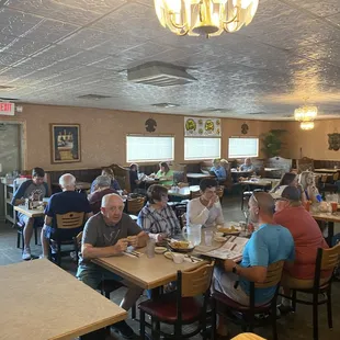 a large group of people sitting at tables in a restaurant