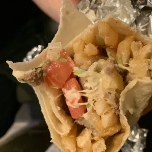 a hand holding a burrito