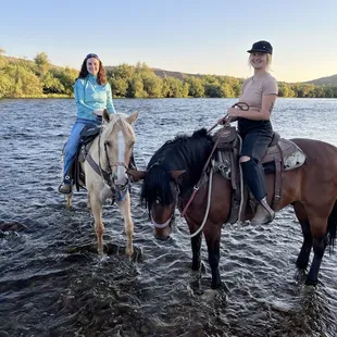 Two friends on horseback in a river