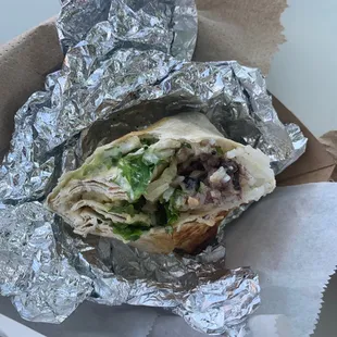 a burrito wrapped in aluminum foil