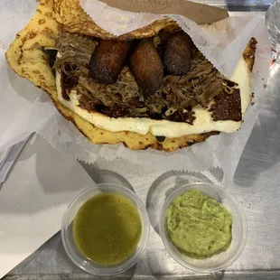 a meat sandwich with a side of guacamole