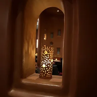 a candle lit in a hole in a wall