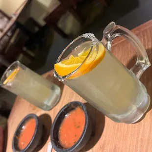 two glasses of lemonade with a slice of orange