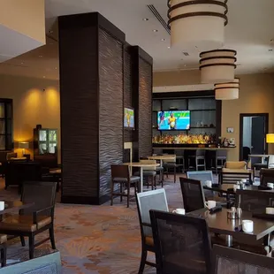 a restaurant with tables and chairs and a flat screen tv