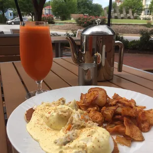 Chesapeake Benedict with lump crab meat and old bay home fries with a fresh carrot apple ginger turmeric juice.