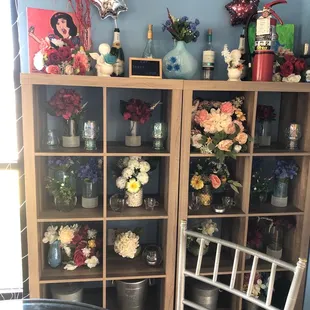 vases of flowers on a bookcase