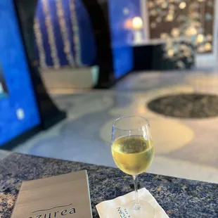 a glass of white wine on a table