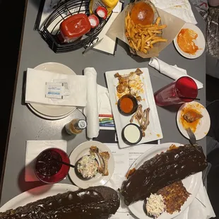 Two whole rack of ribs, with a small portion of coleslaw, cheesy hash browns, and waffle fries. And a kids cheese burger with fries.