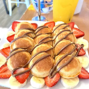 Mini 12 count pancakes drizzled in Nutella with strawberries and banana slices