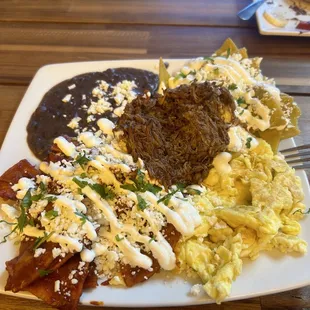 Chilaquiles divorciados with scrambled eggs, birria, and black beans