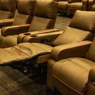 Image features a row of electric recliners with optional heat settings! One chair is fully reclined