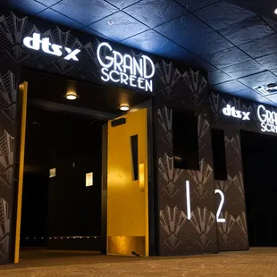 Entrance to 2 Grand Screen auditoriums featuring illuminated Grand Screen with DTS:X signs