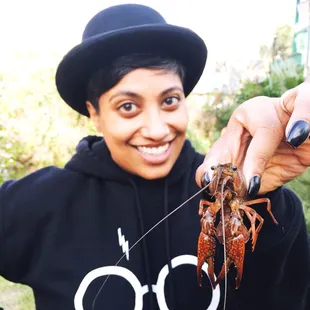 a smiling woman holding a lobster