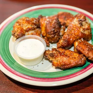 a plate of chicken wings with dipping sauce