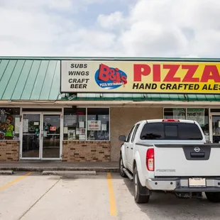 a pickup truck parked in front of a restaurant