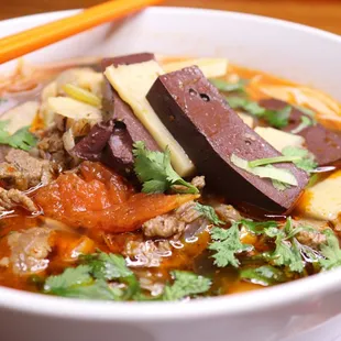 Khao Poun Nam Seen- Slow cook simmered beef soup with vermicelli noodles, bamboo shoots, tomatoes, and juicy tender beef