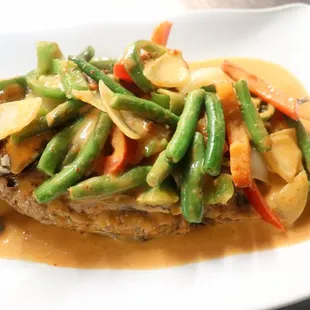 Spicy Curry Tilapia-spicy red curry sautéed with creamy coconut milk, green beans, onions, bell peppers and jalapeños over fried tilapia