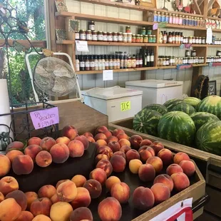 Fruit on display on stands with some of the jarred goods (on the back wall to the right)