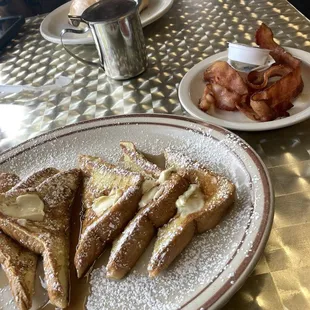 French toast, powdered sugar, butter, cinnamon, roll, bacon, apple juice, and sprite the table hologram