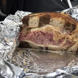 a half of a sandwich wrapped in tin foil