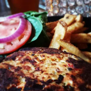 Signature Salmon Burger on brioche bun with lettuce, tomato &amp; onion, served with fries