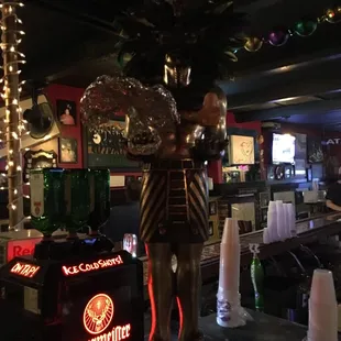 a statue of a skeleton holding a beer