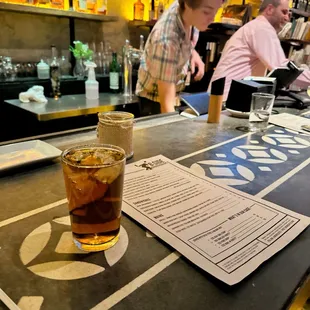 a drink and menu on a bar