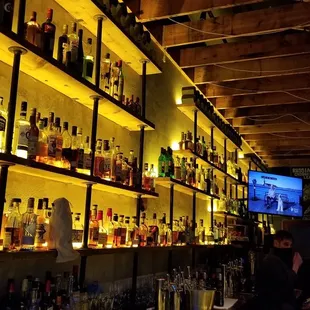 a wall of liquor bottles in a bar