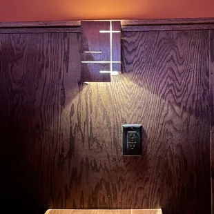 a wood paneled room with a light on the wall