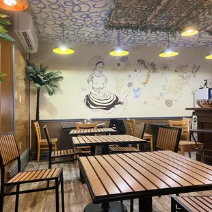 the interior of a restaurant with wooden tables and benches