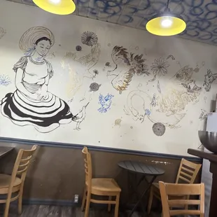 a mural of a woman sitting at a table