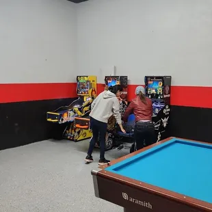 a pool table and arcade machines