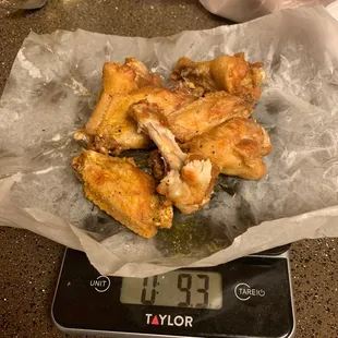 a digital scale with a pile of wings on it