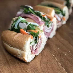 a long line of sandwiches on a wooden table