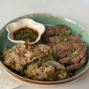 a bowl of rice with meat and vegetables