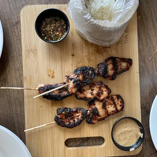 Bbq satay pork served with sticky Thai rice and Thai peanut sauce and a sweet chili sauce