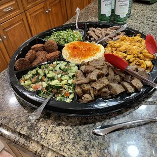 Catering size platter to feed 8 people, comes with rice and couscous sides, pita and sauces