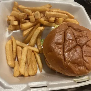 a hamburger and fries in a styrofoam container