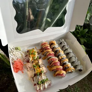 a person holding a box of sushi