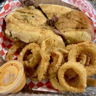 Tri tip sandwich with onion rings and bang bang sauce
