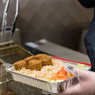 a person holding a tray of food