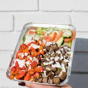 a hand holding a tray of food