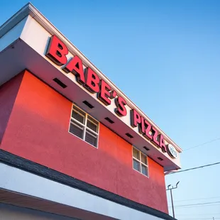 a red building with a sign that says babe&apos;s pizza